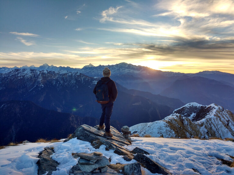 person standing on mountain top watching the sun rise